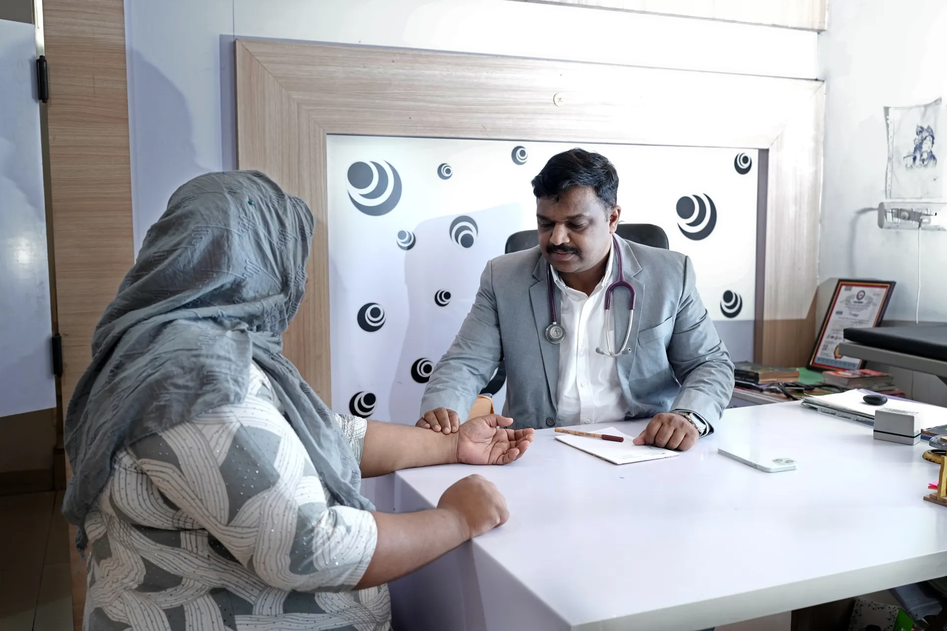 An Ayurvedic physician listening to a patient while reading her pulse