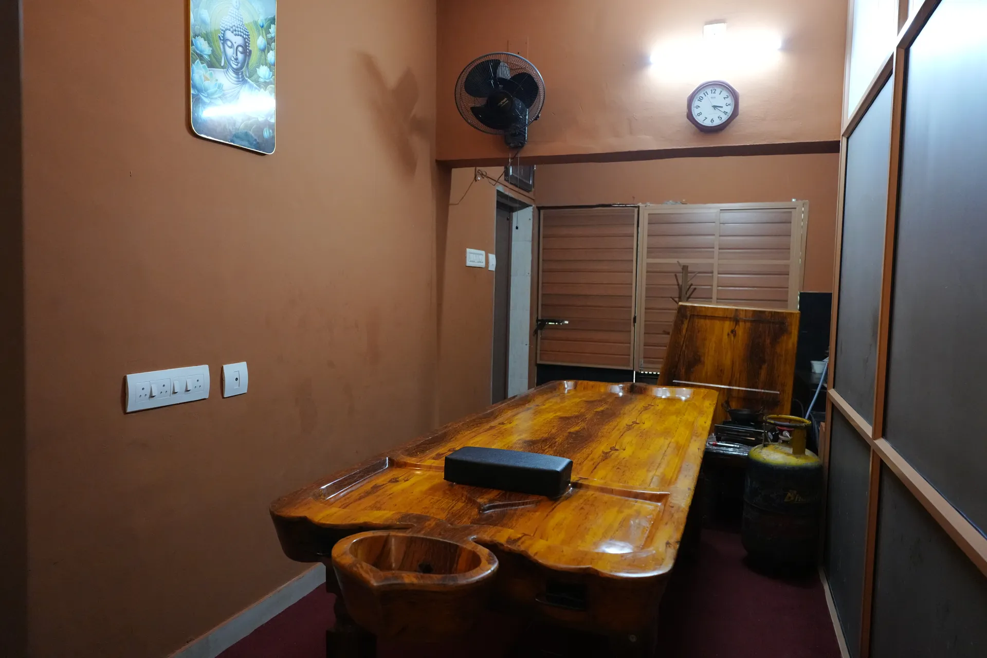A therapist administering Shirodhara in a traditional Ayurvedic treatment room